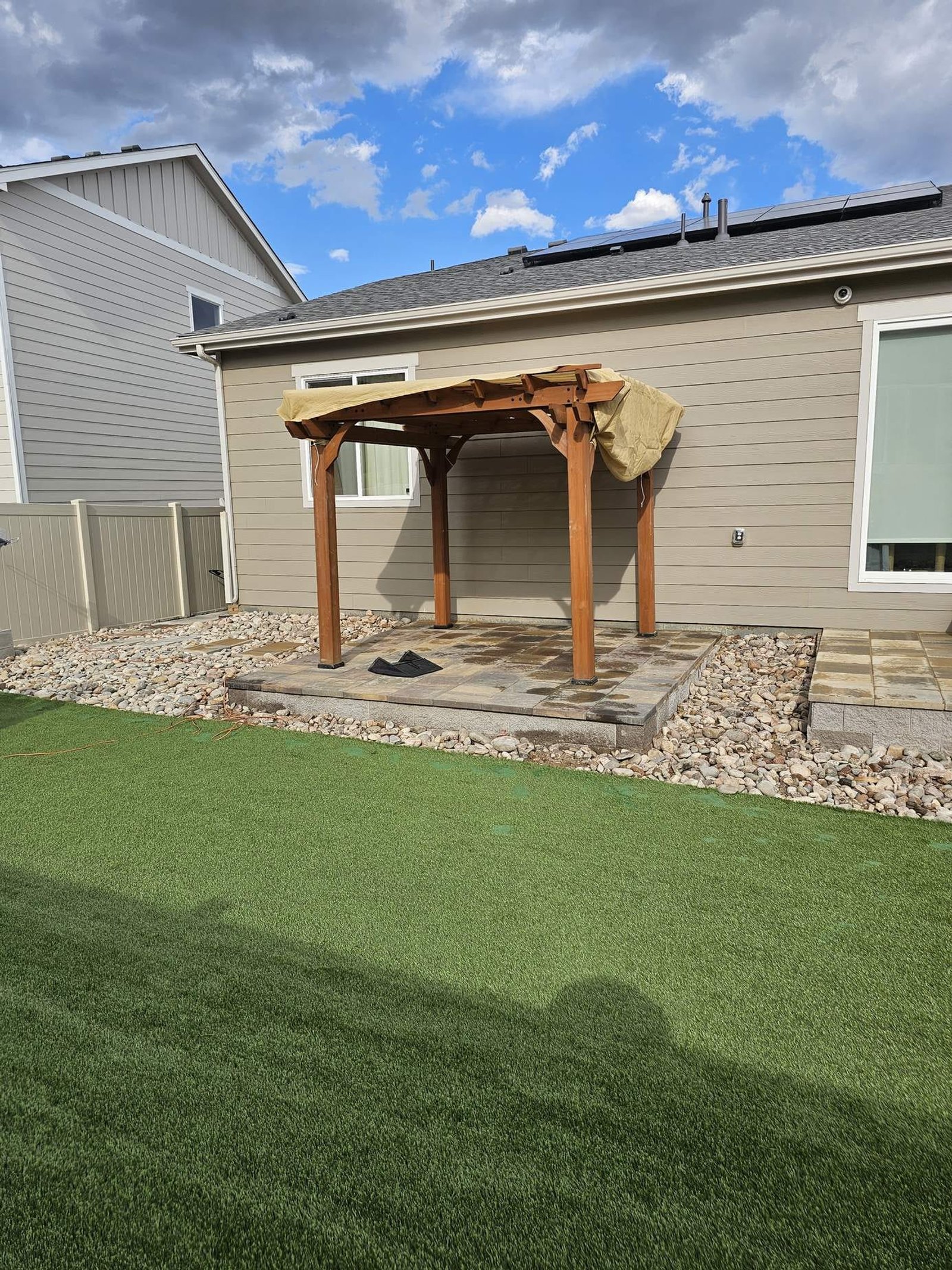 Backyard pergola over a paver patio next to artificial turf at a Colorado Springs home