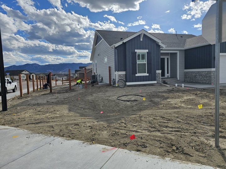 M&J Landscaping crew mid-install grading a base on a Colorado Springs project