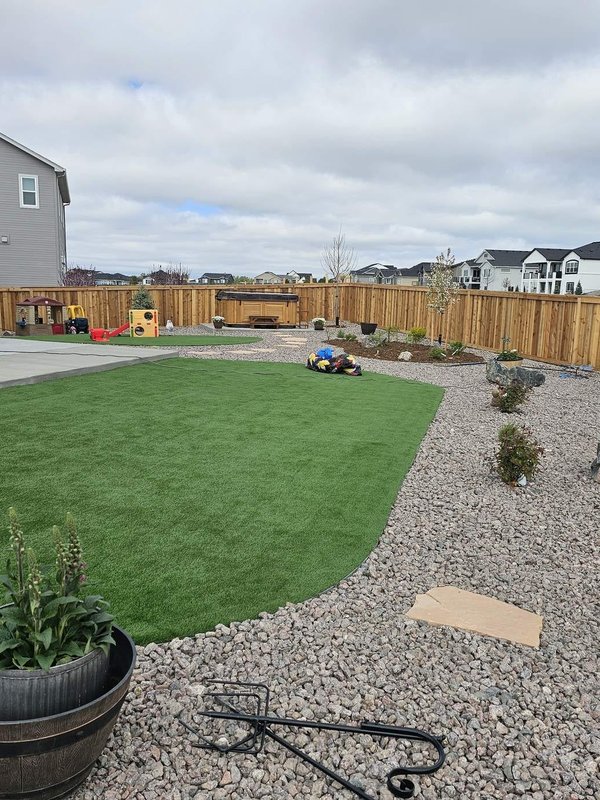New backyard landscaping with a flagstone path and turf accent in Colorado Springs